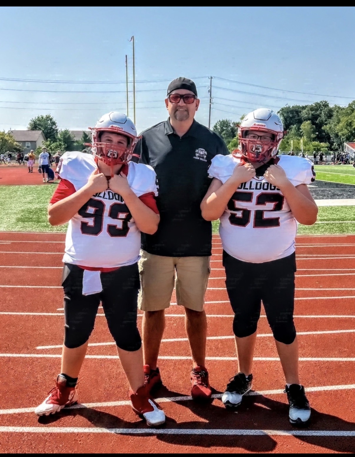 Coach Chris Patrick with two Junior Bulldogs football players